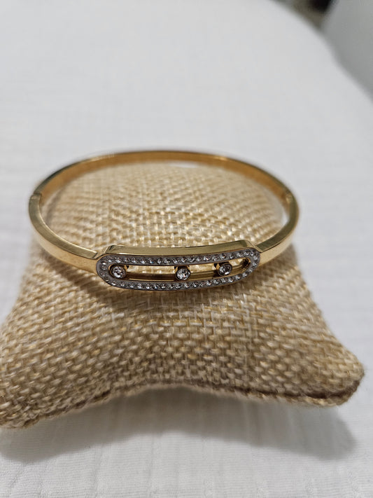 Gold bracelet with a bar and three diamonds  that move inside.