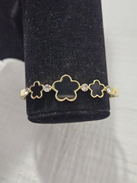 Black bracelet with three leaves in gold.