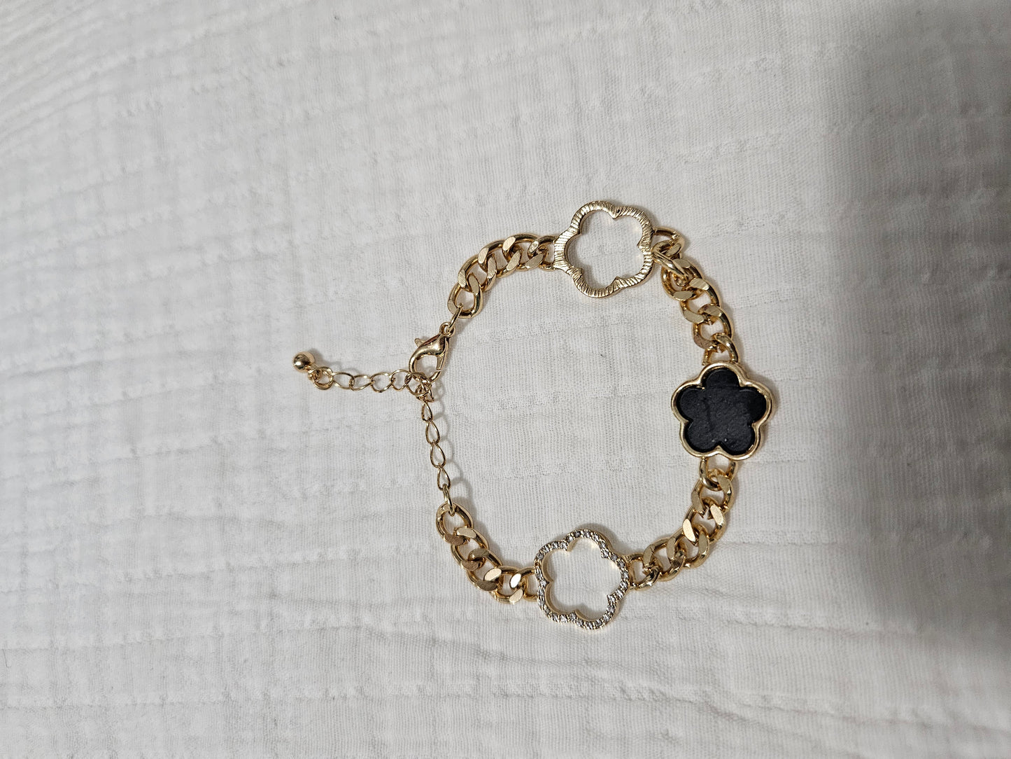 Regular Black bracelet with three leaves in gold.